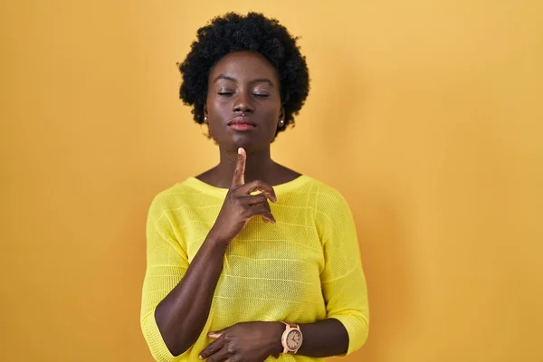 African Young Woman Standing Yellow Studio Thinking Concentrated Doubt Finger — Stock Photo, Image