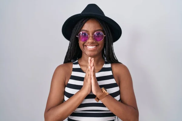Młody Afrykański Amerykanin Warkoczach Kapeluszu Okularach Przeciwsłonecznych Modlący Się Dłońmi — Zdjęcie stockowe