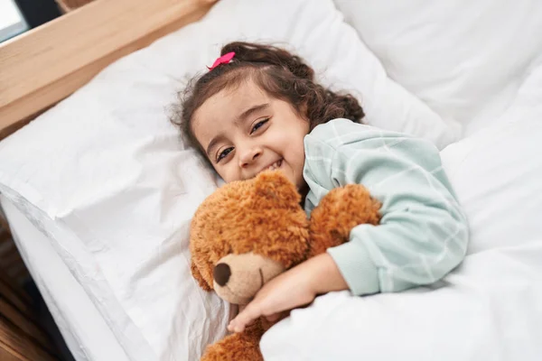 Adorable Hispanic Girl Hugging Teddy Bear Lying Bed Bedroom — Stok fotoğraf