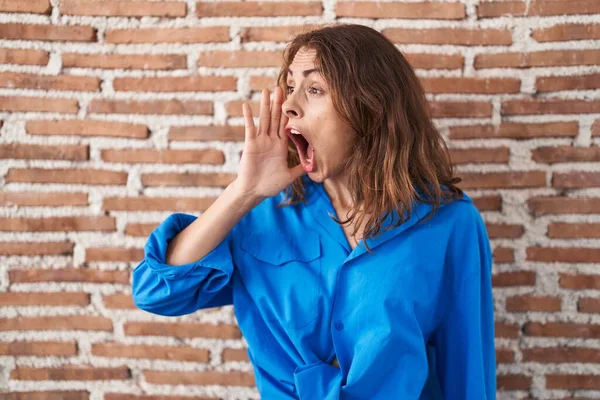 Güzel Esmer Kadın Tuğla Duvarın Üzerinde Durup Ele Tutuşarak Bağırıyor — Stok fotoğraf