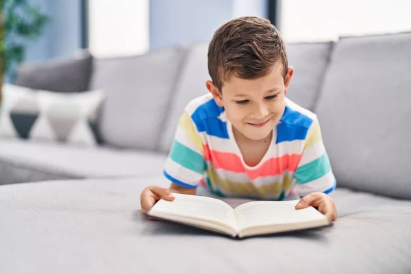 Blond Child Reading Book Sitting Sofa Home — Stock fotografie