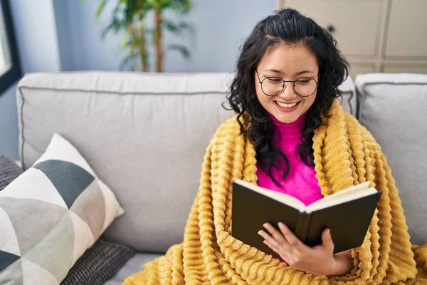 Young Chinese Woman Reading Book Sitting Sofa Home — Stockfoto