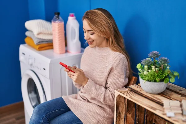 Jovem Mulher Usando Smartphone Espera Máquina Lavar Roupa Lavanderia — Fotografia de Stock