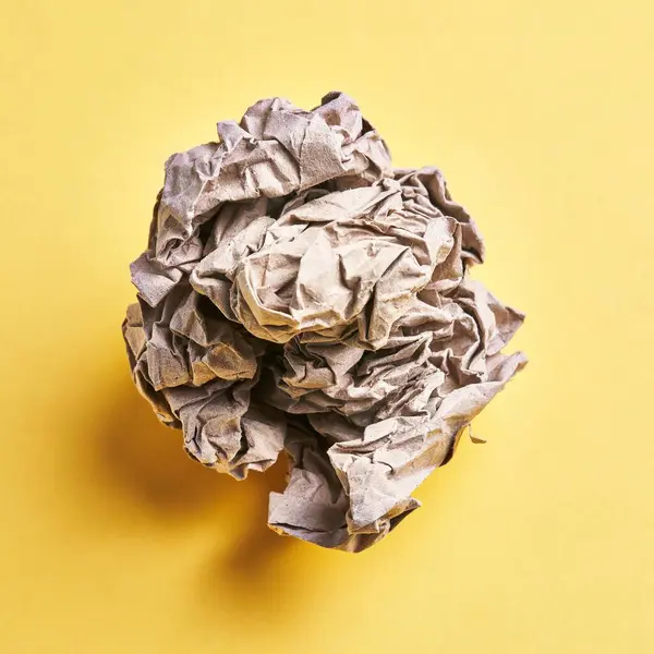 One Brown Crumpled Paper Ball Isolated Yellow Background — Stock Photo, Image