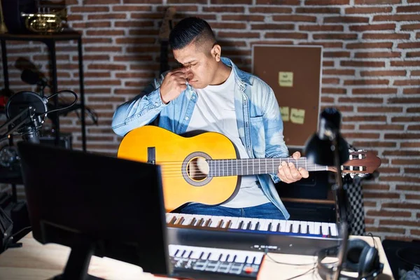 Jovem Hispânico Tocando Guitarra Clássica Estúdio Música Cansado Esfregando Nariz — Fotografia de Stock