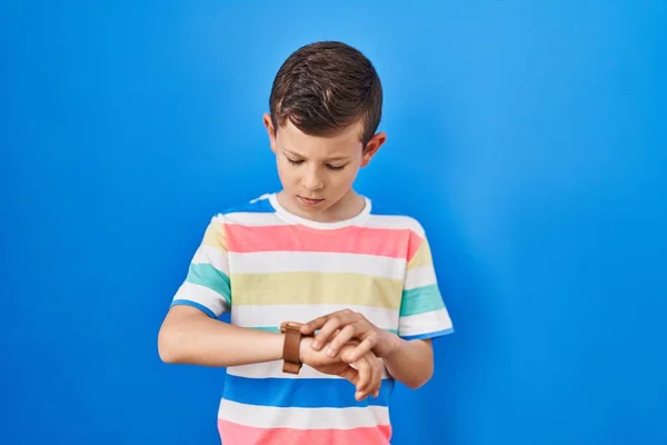 Joven Niño Caucásico Pie Sobre Fondo Azul Comprobar Hora Reloj — Foto de Stock