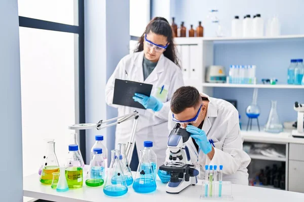 Man Woman Wearing Scientist Uniform Using Microscope Write Document Laboratory — Fotografia de Stock