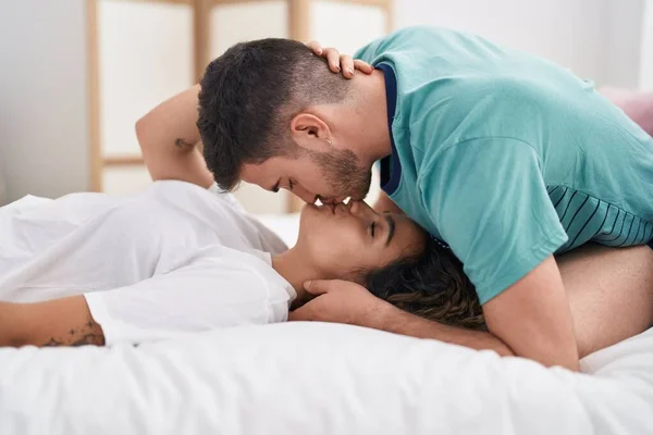 Young Hispanic Couple Lying Bed Hugging Each Other Kissing Bedroom — Stock Fotó
