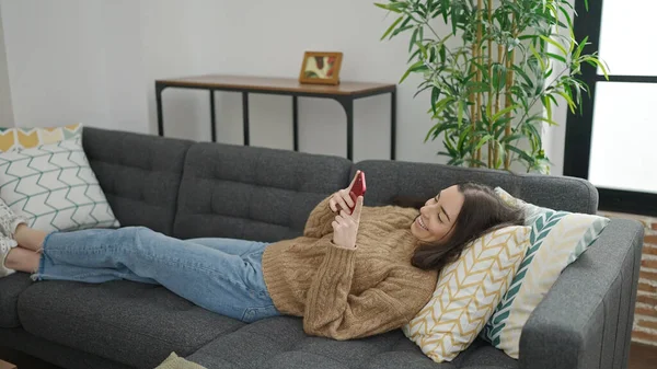 Mujer Hispana Hermosa Joven Usando Teléfono Inteligente Tumbado Sofá Casa — Foto de Stock