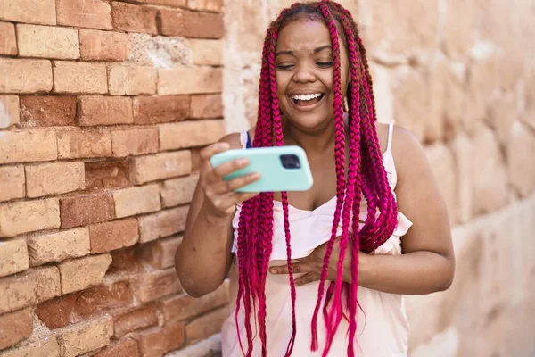 非洲裔美国妇女笑着自信地在街上看智能手机视频 — 图库照片