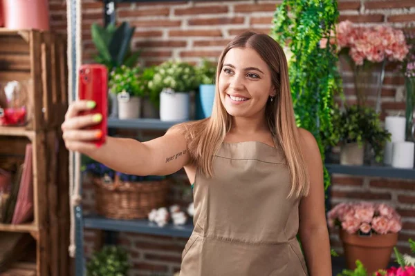 Young beautiful hispanic woman florist make selfie by smartphone at florist
