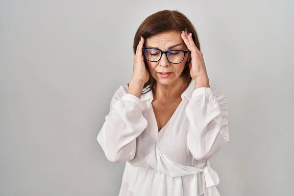 ストレスが原因で頭の中で痛みのために手を頭の上に孤立した背景に立っている中世のパニック女性 片頭痛 — ストック写真