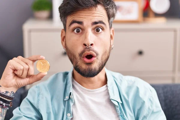 Young Hispanic Man Tattoos Holding Tron Cryptocurrency Coin Scared Amazed — Stock Photo, Image