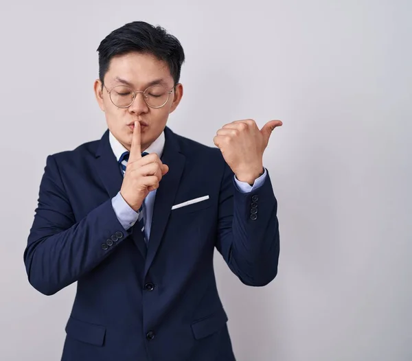 넥타이를 아시아인 남자는 입술을 손가락으로 가리키면서 있기를 — 스톡 사진