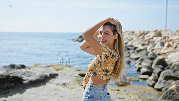 Young Blonde Woman Smiling Confident Combing Hair Seaside — ストック写真