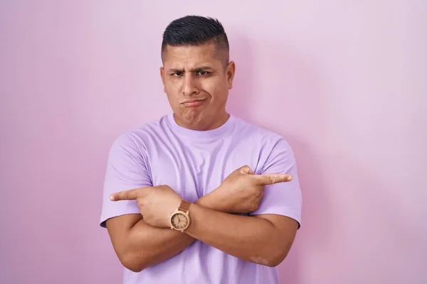 Young Hispanic Man Standing Pink Background Pointing Both Sides Fingers — Stok fotoğraf