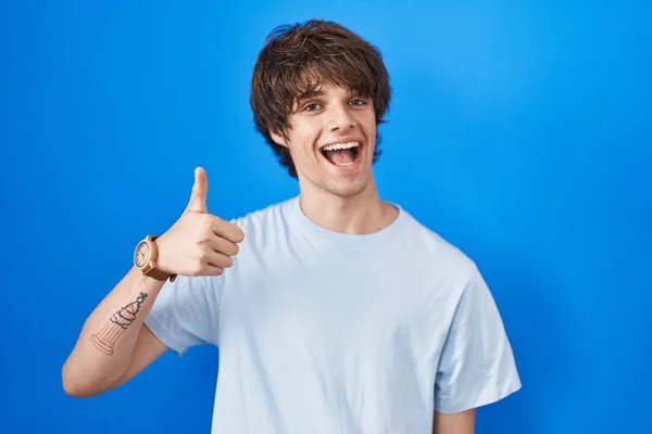 Hispanic Young Man Standing Blue Background Doing Happy Thumbs Gesture — Fotografia de Stock