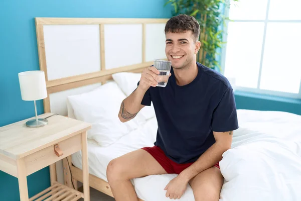 Νεαρός Ισπανός Πίνει Νερό Καθισμένος Στο Κρεβάτι Στην Κρεβατοκάμαρα — Φωτογραφία Αρχείου