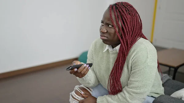 Mujer Africana Con Pelo Trenzado Viendo Televisión Sentado Sofá Buscando —  Fotos de Stock