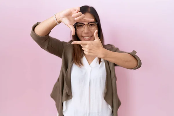 Chińska Kobieta Średnim Wieku Nosząca Okulary Różowym Tle Uśmiechająca Się — Zdjęcie stockowe