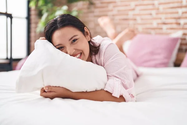 Young Hispanic Woman Hugging Pillow Lying Bed Bedroom — Zdjęcie stockowe