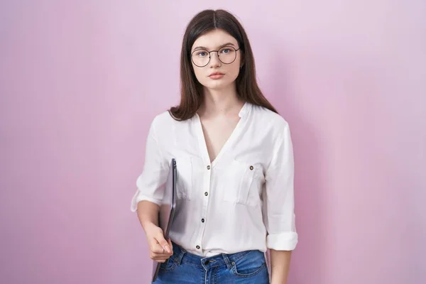 stock image Young caucasian woman holding laptop relaxed with serious expression on face. simple and natural looking at the camera. 