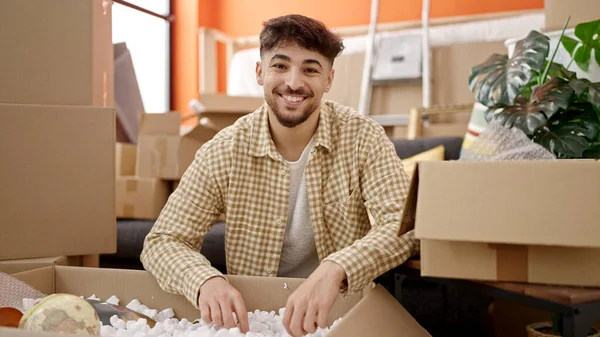 Jovem Árabe Homem Sorrindo Confiante Desembalagem Caixa Papelão Nova Casa — Fotografia de Stock