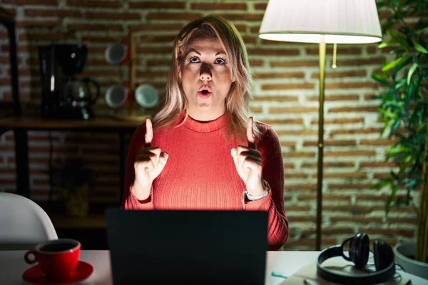 Blond Kvinna Som Använder Laptop Natten Hemma Förvånad Och Förvånad — Stockfoto