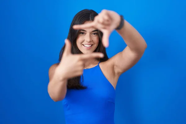Hispanic Woman Standing Blue Background Smiling Making Frame Hands Fingers — 스톡 사진