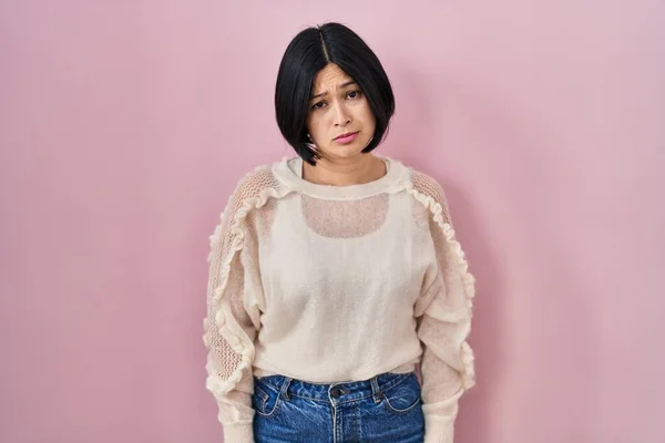 年轻的亚洲女人站在粉红的背景上 沮丧而忧心忡忡 愤怒而又害怕 悲伤的表情 — 图库照片