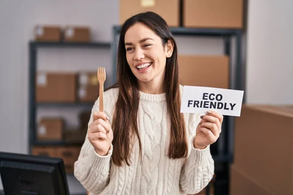 Young brunette woman working at eco friendly ecommerce winking looking at the camera with sexy expression, cheerful and happy face.