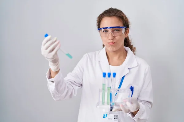 研究室で働く若い白人科学者の女性は 面白い顔で頬をパフサンプル 空気を吸い込み空気を吸い込み — ストック写真
