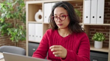 Genç, güzel İspanyol iş kadını ofiste dizüstü bilgisayar kullandığını vurguladı.