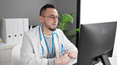 İspanyol doktor klinikte gözlüğünü çıkartıyor.