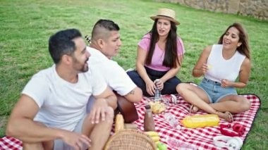 Bir grup insan parkta piknik yapıyor.