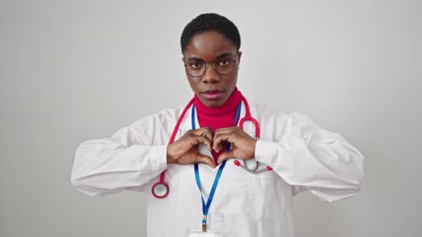African American Woman Doctor Smiling Doing Heart Gesture Hands Isolated — Stock Video