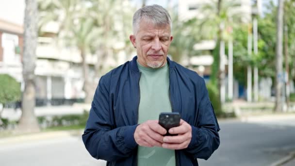 Hombre Pelo Gris Mediana Edad Sonriendo Confiado Usando Teléfono Inteligente — Vídeos de Stock