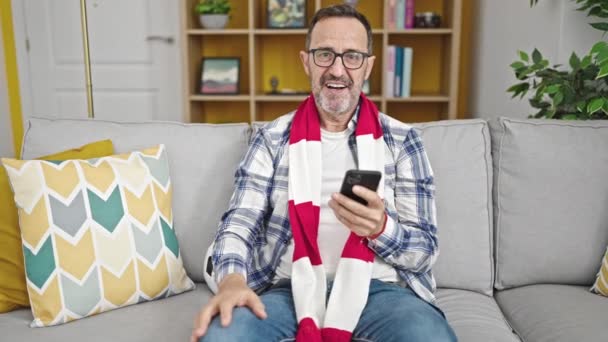 Hombre Mediana Edad Que Apoya Equipo Fútbol Utilizando Teléfono Inteligente — Vídeos de Stock