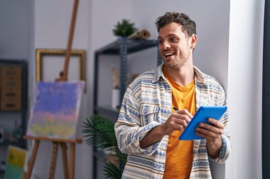 Genç İspanyol ressam, sanat stüdyosunun önünde dokunmatik ped kullanıyor.
