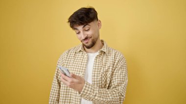 Genç Arap adam gülümsüyor kendinden emin sarı arka planda dolarları tutuyor.