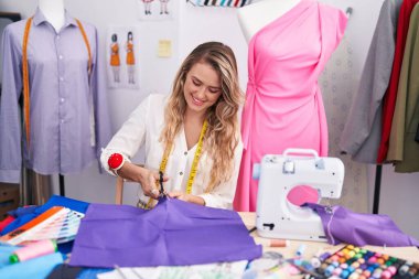 Genç sarışın kadın terzi dükkanında kendine güvenen bir terzi.