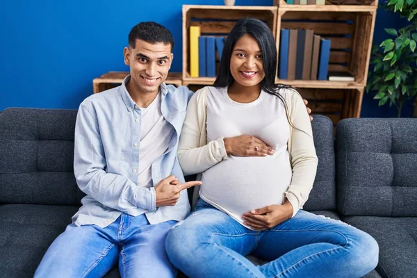 Jong Hispanic Paar Verwacht Een Baby Zitten Bank Thuis Glimlachend — Stockfoto