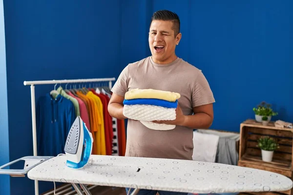 Ισπανόφωνος Νεαρός Άνδρας Κρατώντας Διπλωμένο Πλυντήριο Μετά Σιδέρωμα Κοιτάζοντας Την — Φωτογραφία Αρχείου