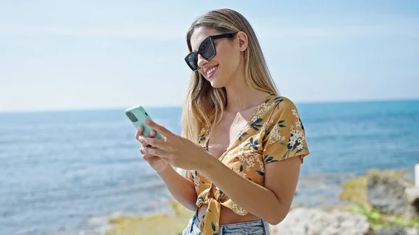 Young Blonde Woman Smiling Confident Using Smartphone Seaside — 스톡 사진