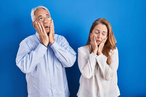 Middle Age Hispanic Couple Standing Blue Background Tired Hands Covering — Stock Photo, Image
