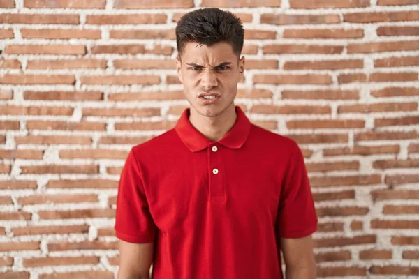 Homem Hispânico Jovem Sobre Tijolos Parede Cético Nervoso Franzindo Testa — Fotografia de Stock