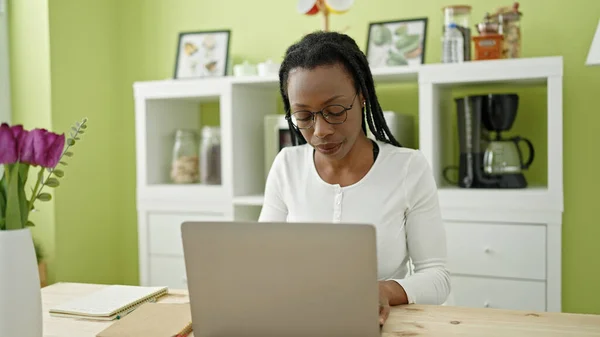 アフリカ系アメリカ人の女性がノートパソコンを使って家のテーブルに座り — ストック写真