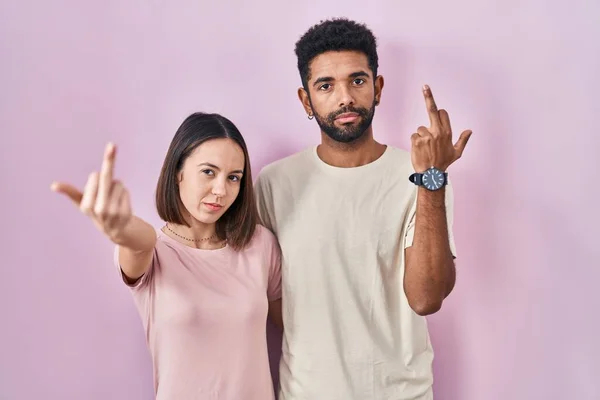 Young Hispanic Couple Together Pink Background Showing Middle Finger Impolite — Zdjęcie stockowe