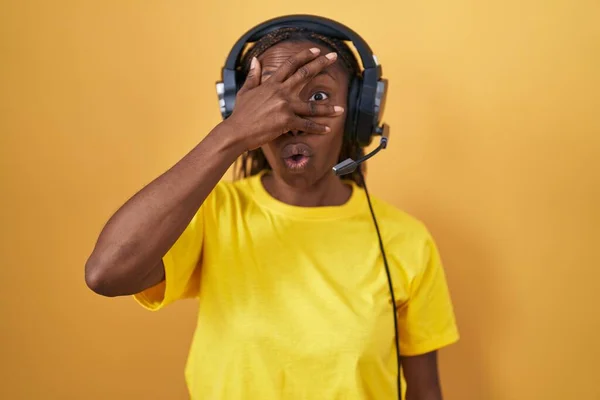 Afroamerikansk Kvinna Lyssnar Musik Med Hörlurar Som Kikar Chocktäckt Ansikte — Stockfoto