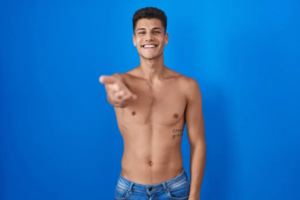Jonge Spaanse Man Staat Shirtloos Blauwe Achtergrond Glimlachend Vrolijk Aanbieden — Stockfoto